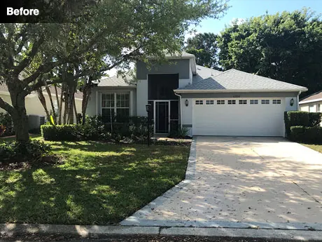 The front of the house before work, with sparse planting on a sloping yard