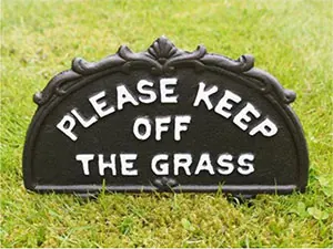 A small &lsquo;keep off the grass&rsquo; sign on a lawn